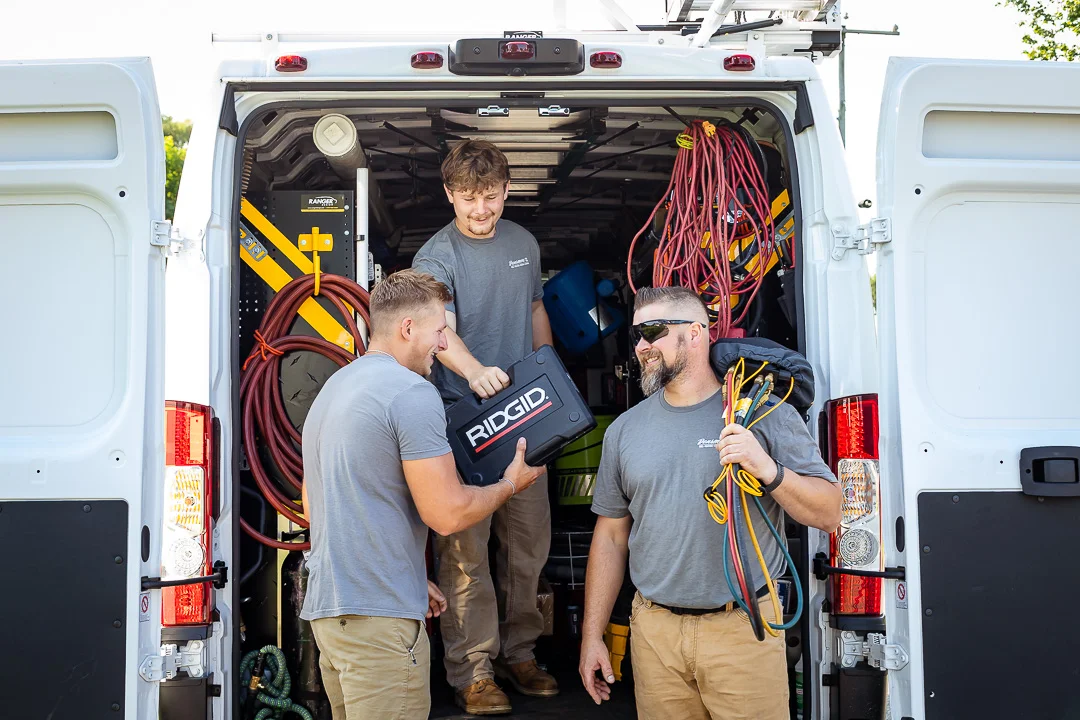Technicians getting tools from truck